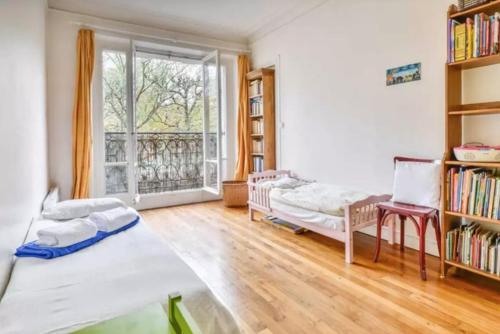 a room with two beds and a book shelf at Appartement de charme entre Montmartre et Batignolles in Paris