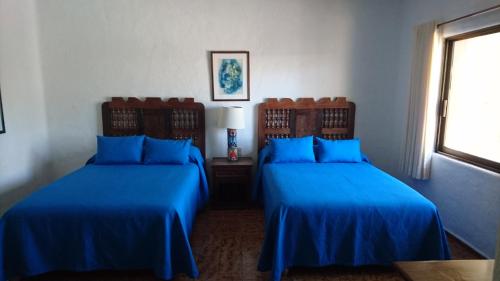 two beds in a room with blue sheets at Villas del Sol en Los Tules in Puerto Vallarta