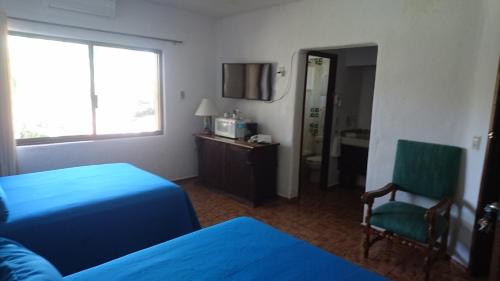 a hotel room with a bed and a chair at Villas del Sol en Los Tules in Puerto Vallarta