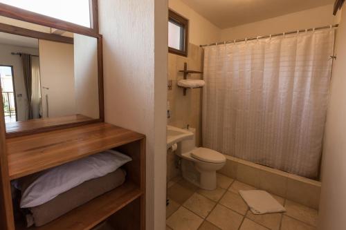a bathroom with a toilet and a shower at Hotel y Centro de Convenciones Jardines del Lago in Panajachel