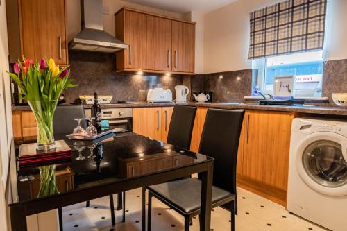 a kitchen with a table and a washing machine at No.3 On The Square in Beauly