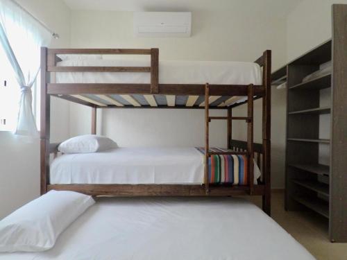 two bunk beds in a room with a window at PlayaTurquesa Moderna Casa C/R Auto a 9 min 5ta ave in Playa del Carmen