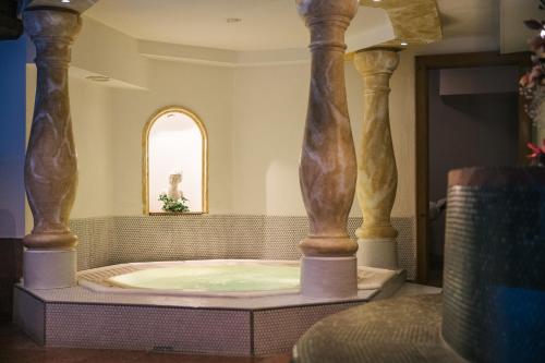 a jacuzzi tub in a room with columns at Hotel Grieshof in Sankt Anton am Arlberg