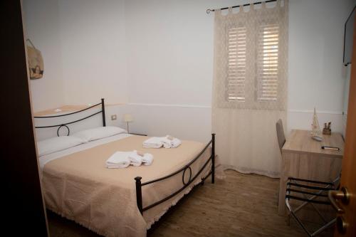 a bedroom with two beds with towels on them at Casamia in Portopalo