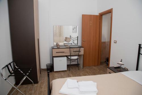 a room with a bed and a desk with a mirror at Casamia in Portopalo