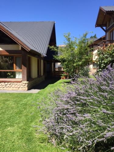 una casa con un patio con flores púrpuras en Ayelen Andina en Esquel