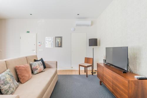 a living room with a couch and a flat screen tv at Augusta Residence Apartments in Lisbon