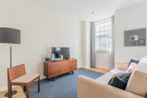 a living room with a couch and a tv at Augusta Residence Apartments in Lisbon