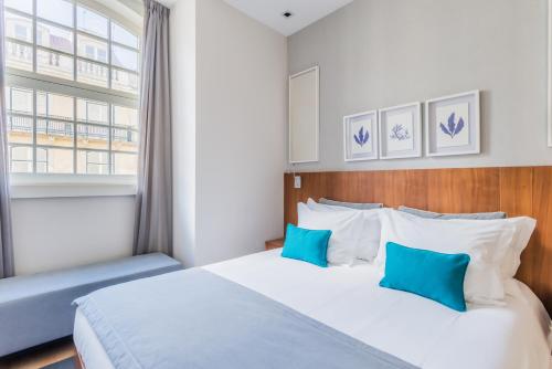 a bedroom with a bed with blue and white pillows at Augusta Residence Apartments in Lisbon