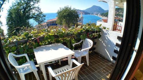 ein Tisch und Stühle auf einem Balkon mit Blick auf das Meer in der Unterkunft Guesthouse Obala in Sutomore
