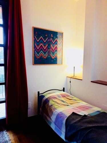 a bedroom with a bed and a painting on the wall at B&B Mo Va Là in Budrio