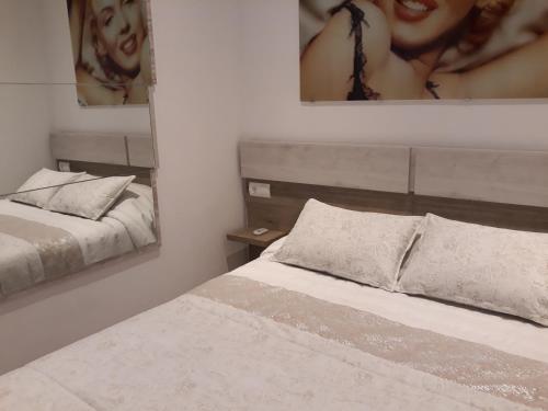 - une chambre avec 2 lits et 2 photos sur le mur dans l'établissement Marilyn, à Roses