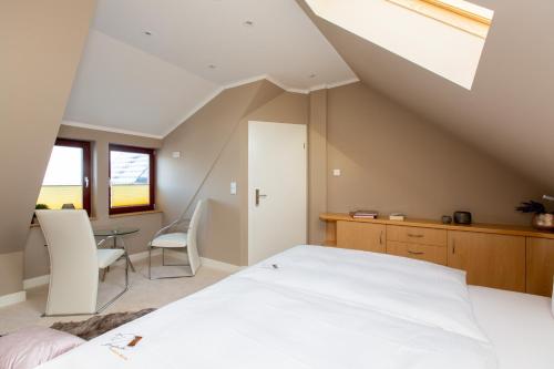 a bedroom with a bed and a table and chairs at Hotel Inselhof in Malchow