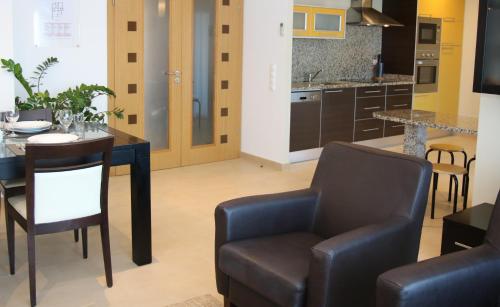 a kitchen with a table and two chairs and a dining room at Pine Tree Apartments - Praia da Coelha - Albufeira in Albufeira