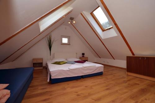 a attic bedroom with a bed and two windows at Hostel Madeira in Gdańsk