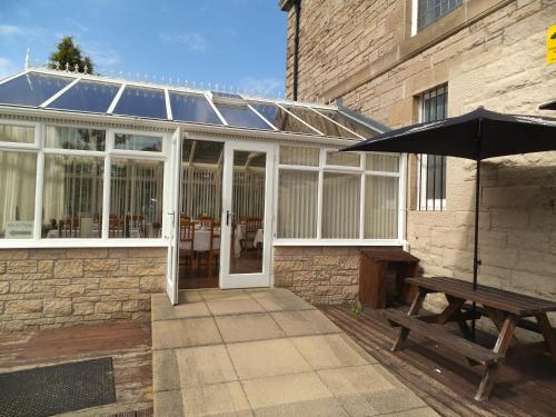 a conservatory with a picnic table and an umbrella at Northumberland Hotel in Edinburgh