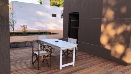 biały stół i krzesła ustawione na tarasie w obiekcie Duplex Rio Uruguay 161 w mieście Monte Hermoso