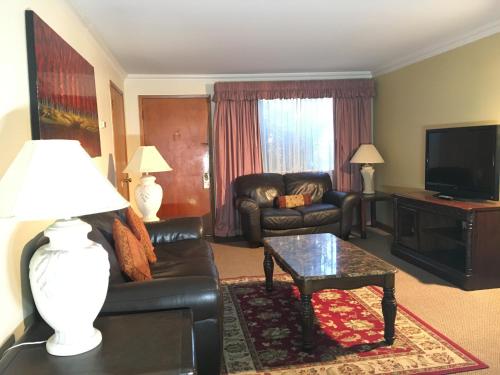 a living room with a couch and a table at Acorn Motor Inn in Oak Harbor