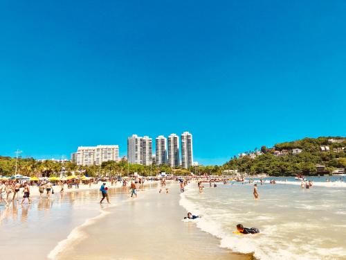 un gruppo di persone su una spiaggia con edifici di Ibiza a Guarujá