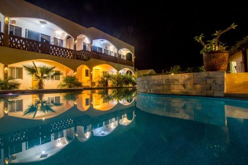a hotel with a swimming pool at night at Olas de Cerritos in El Pescadero