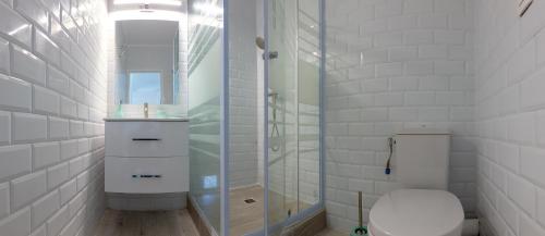 a bathroom with a toilet and a glass shower at Charmant 3 pièces à la marina Pointe du Bout aux 3 ilets in Les Trois-Îlets