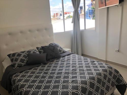 a bedroom with a bed with a large window at Sashii Hostel & Boutique. in Ríohacha