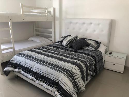 a bedroom with a bed and bunk beds with a ladder at Sashii Hostel & Boutique. in Ríohacha