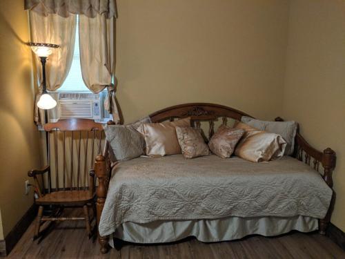 a bedroom with a bed and a chair and a window at Alla's Historical Bed and Breakfast, Spa and Cabana in Dallas