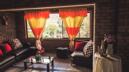 ein Wohnzimmer mit einer Couch und einem Tisch und Fenstern in der Unterkunft Hotel San Gil Nómada in San Gil
