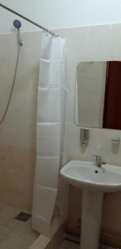 Baño blanco con lavabo y espejo en Гостиница "SEMEY-CITY" en Semey