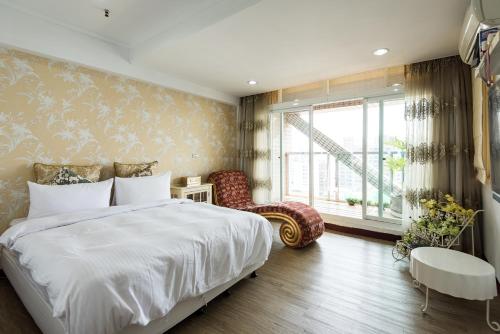 高雄的住宿－星旅店 ，卧室设有一张白色大床和一扇窗户。
