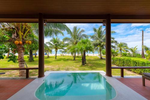 a swimming pool in a house with a view of the ocean at C&N Kho Khao Beach Resort - SHA Plus in Ko Kho Khao