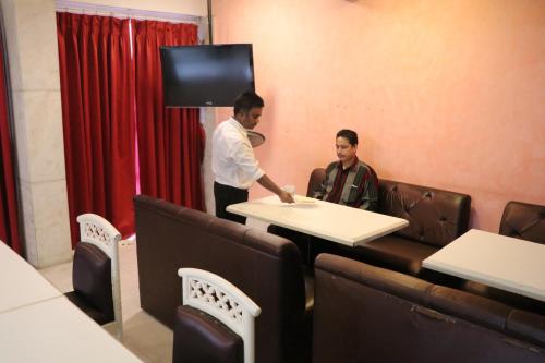 two men standing in a room with a table at Hotel Milan International in Mumbai