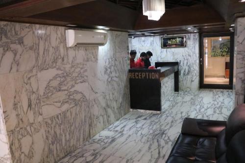 a lobby with a counter with a marble wall at Hotel Milan International in Mumbai