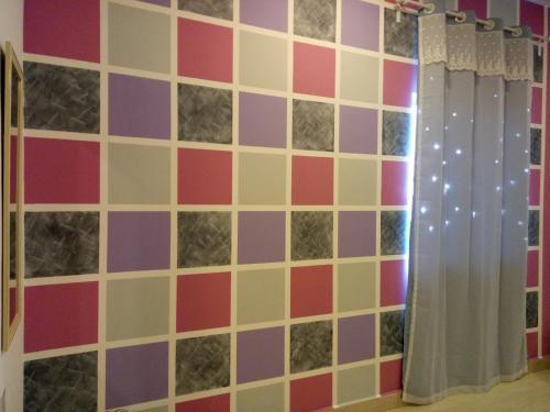a tiled wall with purple and pink at ICOLOR HOME & STAY CH1 in Tanah Rata
