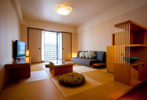 a living room with a couch and a television at RIHGA Royal Hotel Kyoto in Kyoto