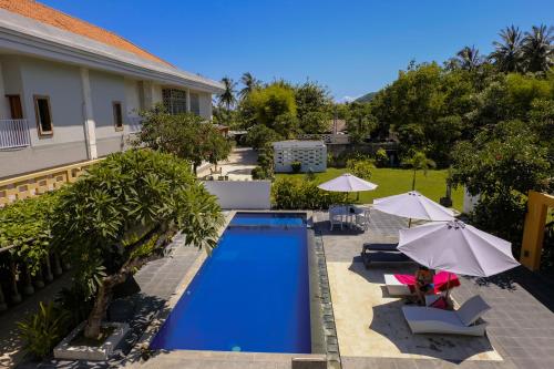 an overhead view of a swimming pool with umbrellas at JM Hotel Kuta Lombok in Kuta Lombok