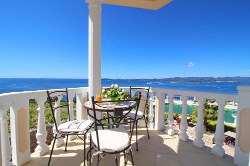 a balcony with a table and chairs overlooking the ocean at Hotel Pansion Villa Antonio in Orebić