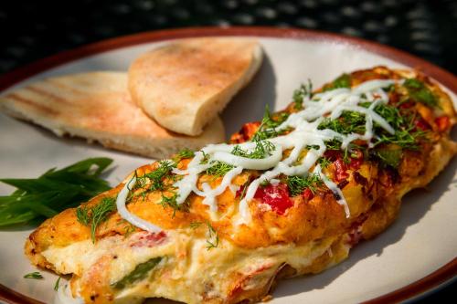 um prato com um pedaço de pizza com queijo e verduras em Papa Jolly Eco Resort-Near Morjim Beach em Morjim