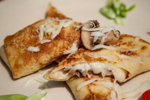 um prato de comida com cogumelos por cima em Papa Jolly Eco Resort-Near Morjim Beach em Morjim