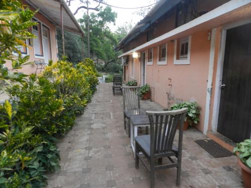 a patio with chairs and a table and a house at Sayeban Hotel in Matheran