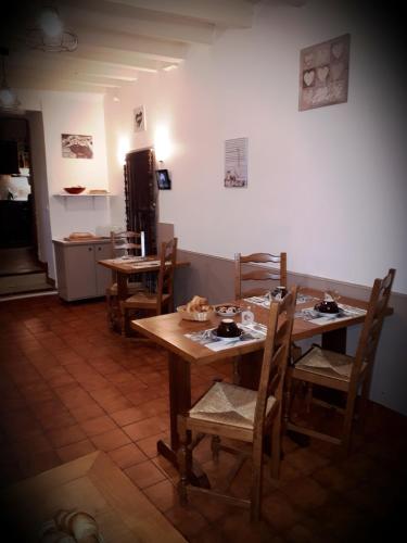 a dining room with wooden tables and chairs at Aux Chambres du Mont in Huisnes-sur-Mer