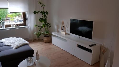 a living room with a flat screen tv on a white cabinet at Gästewohnung Flora in Taucha