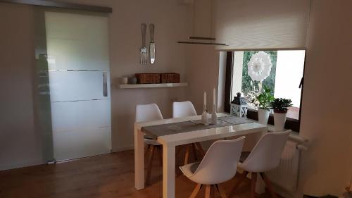 a kitchen with a table and chairs and a refrigerator at Gästewohnung Flora in Taucha
