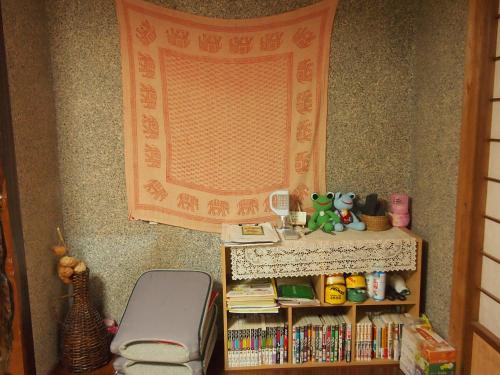 a room with a shelf of books and a window at Tirol in Yakushima