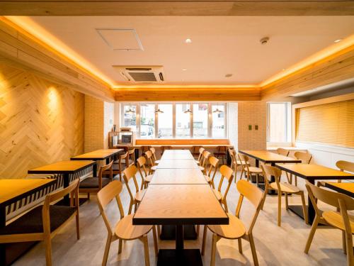 uma sala de jantar com mesas e cadeiras de madeira em Super Hotel Takamatsu Kin en kan em Takamatsu