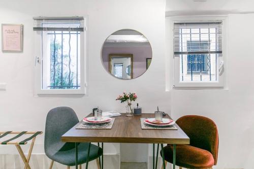 a dining room table with chairs and a mirror at Artistic Antibes Apartment in Antibes