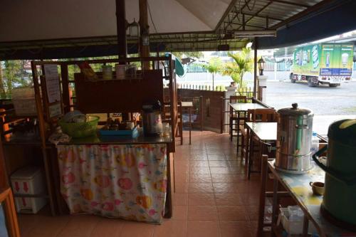 un restaurante con mesa y sillas y un autobús en MG Guesthouse, en Sukhothai