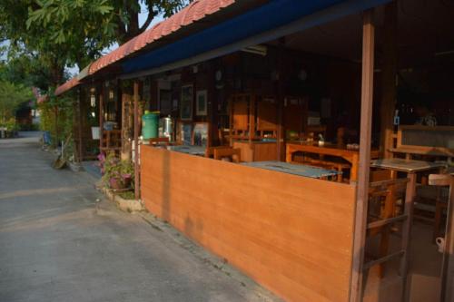 a building with a wooden fence next to a street at MG Guesthouse in Sukhothai