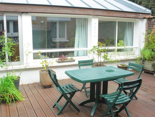un patio avec une table et des chaises sur une terrasse dans l'établissement Lille au calme - chambre d'hôte M et Me Collet, à Lille